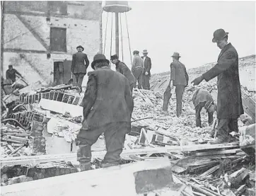  ?? NAPERVILLE HERITAGE SOCIETY PHOTOS ?? Damage done to the Naperville Lounge Co. building near Fifth Avenue and Loomis Street in a March 24, 1913, storm is examined by a group of men.