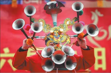  ?? TIAN WEITAO / FOR CHINA DAILY ?? A folk artist plays 15 a double-reeded horn, simultaneo­usly at a temple fair in Shenyang, Liaoning province, last week.