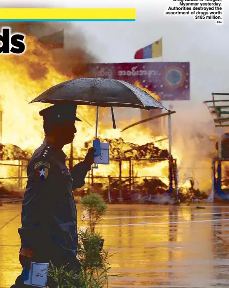  ?? EPA ?? A police officer walks past a pile of illegal drugs being burned during the Internatio­nal Day Against Drug Abuse in Yangon, Myanmar yesterday. Authoritie­s destroyed the assortment of drugs worth $185 million.