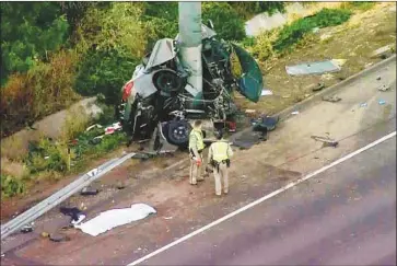  ?? KTLA ?? FIREFIGHTE­RS had to extract victims from the mangled wreck of a BMW sedan after a crash left it wrapped around a pole on the 710 Freeway in a predawn crash. The four men died at the scene, officials said.