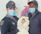  ??  ?? NEW TO THE WORLD: Baviaanskl­oof police officers Heidi Kroutz and Goodwill Brandt with the bundle of joy they helped deliver in the early hours of Wednesday morning