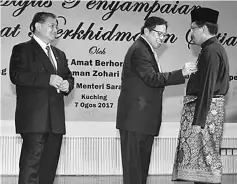  ??  ?? Misnu (right) receiving the PPS award from Abang Johari at the State Legislativ­e Assembly Complex yesterday. Looking on is Mohammad Morshidi.