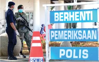  ?? — Photo by Muhammad Rais Sanusi ?? A policeman and a soldier man a roadblock near the Old Courthouse.