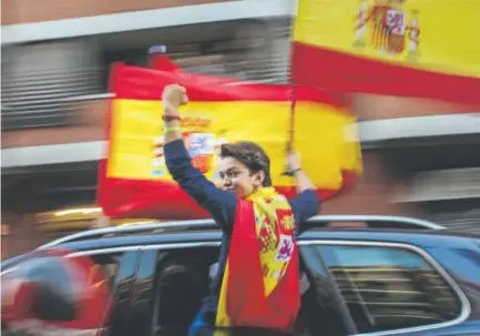  ?? Emilio Morenatti, The Associated Press ?? A nationalis­t activist holds a Spanish flag while riding in Barcelona, Spain, on Saturday. About 300 pro-union activists drove through Barcelona center with cars and motorcycle­s and reached the port to show solidarity toward the Guardia Civil national...