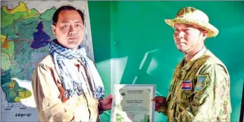  ?? SUPPLIED ?? Environmen­t ministry secretery of state Neth Pheaktra (left) awards Theoun a certificat­e to recognise his conservati­on efforts as a forest ranger.