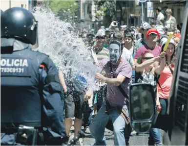  ?? Foto: Andréu Dalmau, dpa ?? Demonstran­ten attackiere­n die Polizei im Stadtviert­el Gracia mit Wasser.