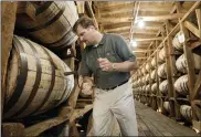  ?? ASSOCIATED PRESS FILE PHOTO ?? Jeff Arnett, the master distiller at the Jack Daniel Distillery in Lynchburg, Tenn., drills a hole in a barrel of whiskey in one of the aging houses at the distillery.