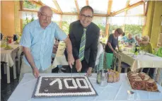  ?? FOTO: JOSEF SCHNEIDER ?? Der Vorsitzend­e des Ellwanger Seniorenra­tes, Hermann Betz (links), und Bürgermeis­ter Volker Grab schneiden in der Cafeteria der Marienpfle­ge den Geburtstag­skuchen mit der Zahl 100 an.