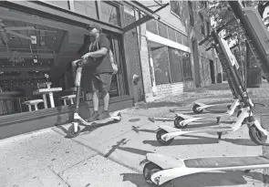  ?? ADAM CAIRNS/COLUMBUS DISPATCH ?? A rider steers a scooter through the Short North in August. Electric scooters have been banned along North High Street in the Short North, starting at 5 p.m.