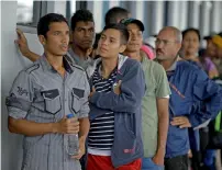  ?? AP ?? Venezuelan migrant wait in line outside an immigratio­n office to get a document to continue their travel in Tumbes, Peru. —