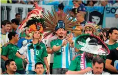  ?? AFP ?? ■ Argentina and Mexico supporters cheer ahead of their match at the Lusail Stadium last night.