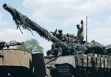  ?? ?? DEFENSIVA. Tropas ucranianas saludan desde un tanque en la región oriental de este país.