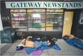  ?? AP PHOTO/MIKE STEWART ?? Homeless men sleep in 2020 on Marietta Street in Atlanta.