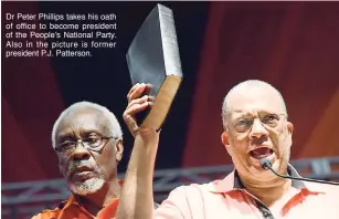  ??  ?? Dr Peter Phillips takes his oath of office to become president of the People’s National Party. Also in the picture is former president P.J. Patterson.