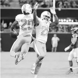  ?? CURTIS COMPTON/TNS ?? Dolphins S Reshad Jones (20) celebrates his late INT with fellow DB Xavien Howard during Sunday’s win in Atlanta. The defense held the Falcons scoreless in the 2nd half.