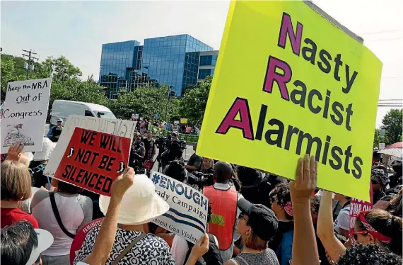  ?? JONATHAN ERNST ?? Anti-NRA protesters outside the National Rifle Associatio­n headquarte­rs in Fairfax, Virginia, in July.