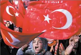  ?? PETROS KARADJIAS/AP ?? A woman participat­es Monday in a rally against the recent failed coup attempt in Turkey.