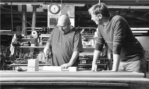  ??  ?? Gaston ‘Gat’ Caperton, right, is the owner of Gat Creek Furniture in Berkeley Springs, West Virginia. Caperton chats with craftsman David Michael at a workbench on the the factory floor.