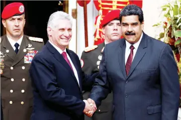  ??  ?? Maduro (right) and Diaz-Canel shake hands during his welcoming ceremony at the Miraflores Palace in Caracas. — Reuters photo