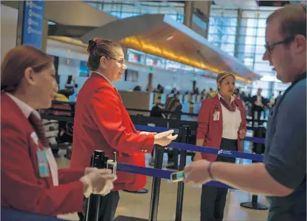  ?? Marcus Yam Los Angeles Times ?? AIRPORT WORKERS check passengers’ boarding passes before letting them through to the security lines at Los Angeles Internatio­nal Airport’s Tom Bradley Internatio­nal Terminal. Homeland Security announced enhanced aviation security measures Wednesday.