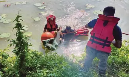  ??  ?? Pasukan bomba membawa naik mayat M Lurouthusa­my Jayasingam yang ditemui lemas ketika mengutip bunga teratai di tasik bekas lombong di Taman Muhibbah Jaya, Sungai Siput, semalam