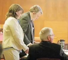  ?? [PHOTO BY LYNN L. MARTIN, ALVA REVIEW-COURIER] ?? Katherine Rutan stands with her defense team, Gerald Weis, center, and Larry Jordan, seated, during her first-degree murder trial in August 2007 in Alva.