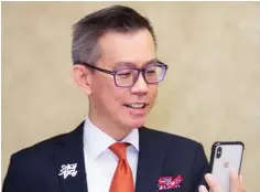  ??  ?? Lim looks into his iPhone X to activate biometric access to his accounts.