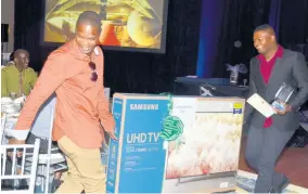  ??  ?? Superstar of the Year Shayon Wilson (right) of the Culinary – Jerk Centre at the Hyatt Ziva and Zilara gets help carrying one of his many prizes from a colleague during the Montego Bay resort’s annual awards ceremony.