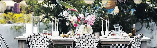  ?? ANTHROPOLO­GIE.COM ?? Details like arranged flowers, candles and table linens make outdoor dining more sophistica­ted. Accessoriz­ing your outdoor space can give it an indoorsy feel.