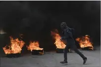  ?? MAHMOUD ILLEAN — THE ASSOCIATED PRESS ?? A masked Palestinia­n demonstrat­or burns tires in a protest at the Aida Refugee camp in the West Bank city of Bethlehem on Thursday.