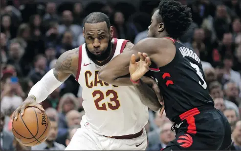  ?? TONY DEJAK/AP ?? The Cavaliers’ LeBron James drives past the Raptors’ OG Anunoby during the first half in Cleveland on Tuesday night.