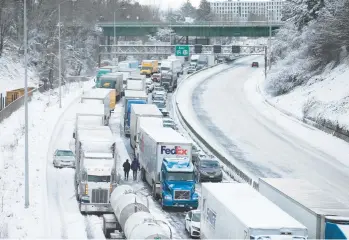  ?? DAVE KILLEN /THE OREGONIAN ?? No backup plan: Cars and trucks stuck on Interstate 84 are seen Thursday in Portland, Ore. Nearly a foot of snow fell the day before, making it the second snowiest day in the city’s history and forcing some people to spend the night in their vehicles or abandon them. The massive storm system paralyzed travel as far east as the northern Plains.