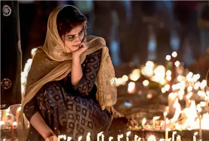  ?? PTI ?? A woman lights candles at Bangla Sahib Gurudwara in New Delhi on the 550th birth anniversar­y of Guru Nanak Dev ji, the first guru of Sikhs, on Friday. —