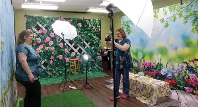  ?? (Photo by Neil Abeles) ?? Starr Ferrusquia is getting her own profession­al portrait made by Atlanta Public Library Librarian Kendra Harrell. Starr’s family will join her next. The service, she said, is an example of the benefit a local library provides for a town.