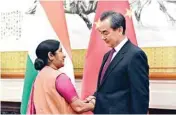  ??  ?? Indian Foreign Minister Sushma Swaraj shakes hands with her Chinese counterpar­t Wang Yi prior to a meeting at the Diaoyutai State Guesthouse in Beijing on Sunday