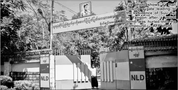  ??  ?? File photo shows a man closing a gate leading to the residence of Suu Kyi in Yangon after a petrol bomb was hurled into the compound. — AFP photo