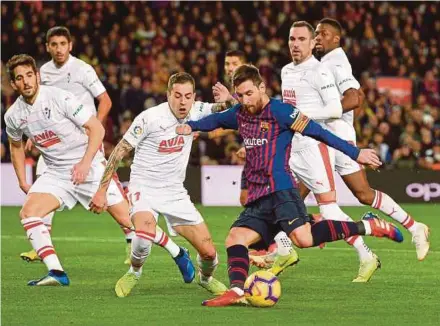  ?? AFP PIC ?? Barcelona’s Lionel Messi (centre) is surrounded by Eibar players at the Nou Camp on Sunday.