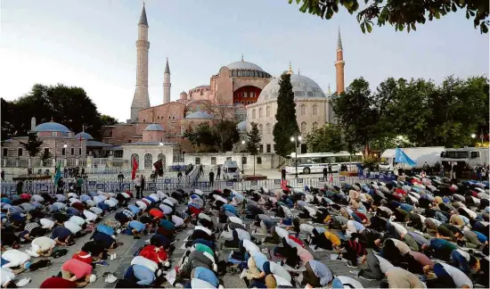  ?? Murad Sezer/Reuters ?? Muçulmanos realizam oração da tarde em frente à agora mesquita Hagia Sophia, em Istambul, na Turquia