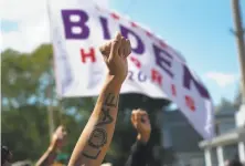  ?? Chang W. Lee / New York Times ?? Supporters raise a banner for Democratic presidenti­al candidate Joe Biden where he spoke Thursday in Kenosha, Wis.