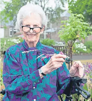  ??  ?? Margaret Smith holding the plant she found a year after the embassy siege in London, which was eventually ended by special forces.