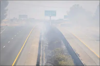  ?? BEA AHBECK/NEWS-SENTINEL ?? Highway 99 is completely shut down as fire crews from several department­s fight a fire which spread to both sides of the freeway and threatened structures in Galt on Wednesday.