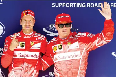  ?? — AFP photo ?? Ferrari's German driver Sebastian Vettel (L) and Ferrari's Finnish driver Kimi Raikkonen pose after the qualifying at the Hungarorin­g racing circuit in Budapest on July 29, 2017 prior to the Formula One Hungarian Grand Prix.