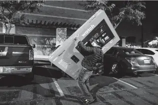  ?? Ringo H.W. Chiu / Associated Press ?? A Black Friday shopper leaves Walmart with a TV in Pic Rivera, Calif. From appliance stores in the U.S. to food markets in Eastern Europe, rising consumer prices are putting a pinch on households.