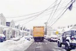  ?? MICHAEL LOCCISANO/GETTY IMAGES ?? A box truck drives down a street in North Bergen, New Jersey. Snow accumulati­on has shut down more New Jersey vaccine sites and has been a strain on timely vaccine delivery.