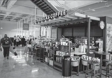  ?? RICK WOOD / RWOOD @JOURNALSEN­TINEL.COM ?? A Starbucks Coffee is located near the entrance and checkout areas of Roundy’s upscale Metro Market in Shorewood, which will open on Tuesday. The market on N. Oakland Ave. also will feature a bar, a pizzeria and a bakery.