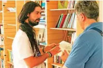  ??  ?? Muhannad Qaiconie, one of the founders of the 'Baynetna' cultural center in Berlin speaks to a visitor to the center's library. — AP photos