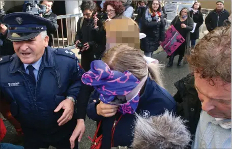  ??  ?? The 19-year-old British woman, centre, leaves Famagusta District Court in Paralimni, Cyprus, after she was found guilty of lying about being gang-raped