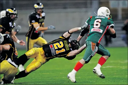  ?? — GETTY IMAGES FILES ?? Oliver Friedrich of Berlin Adler tries to make a diving tackle of Baltic Kiel ball-carrier Simon Sommerfeld during a past German Bowl championsh­ip game in Frankfurt. There are 65,000 gridiron-style football players in Germany.