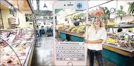  ?? INMA SAINZ DE BARANDA ?? Eva Puerto muestra la aplicación en el mercado de Sant Gervasi