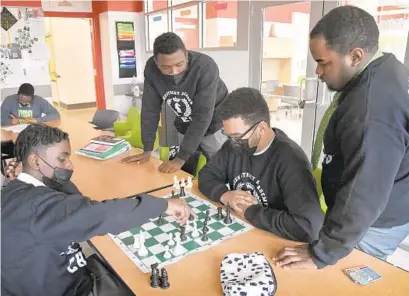  ?? AMY DAVIS/BALTIMORE SUN PHOTOS ?? Green Street Academy sophomore Marquel “Socks”Johns, left, plays a game with junior Javier Gomez, 17, as sophomore Jaylin Liggins, 18, standing second from left, and senior Kanye Carney, 18, watch.